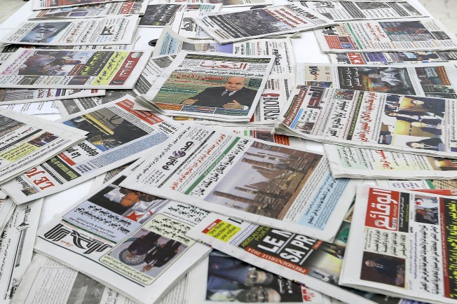 A collection of newspapers spread on a table.