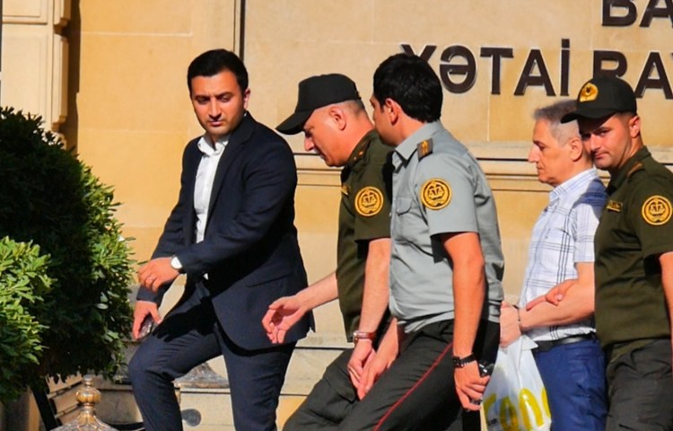 Toplum TV founder Alasgar Mammadli (second from right), enters Baku's Khatai District Court for a hearing on July 3, 2024. Mammadli is one of 11 Azerbaijani journalists held in pretrial detention on charges of currency smuggling. (Photo: Farid Ismayilov)