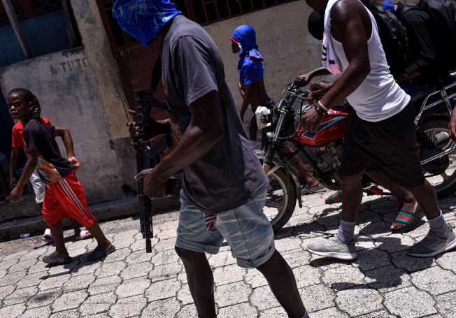 Children accompany armed gang members in a march organised by former police officer Jimmy "Barbecue" Cherizier, leader of an alliance of armed groups, in the Delmas neighbourhood, in Port-au-Prince, Haiti, May 10, 2024. Nearly half of the country's population is struggling to feed themselves due to the conflict, since the 2021 assassination of Haiti's last president, armed gangs have expanded their power and influence, taking over most of the capital and expanding to nearby farmlands. "If you are displaced or your family doesn't have a place to sleep, you may need to join armed groups just to cover your needs," said Save the Children Haiti food advisor Jules Roberto. REUTERS/Pedro Valtierra Anza SEARCH "ARDUENGO VALTIERRA HAITI HUNGER" FOR THIS STORY. SEARCH "WIDER IMAGE" FOR ALL STORIES. TPX IMAGES OF THE DAY - RC2RN8AJCNUV
