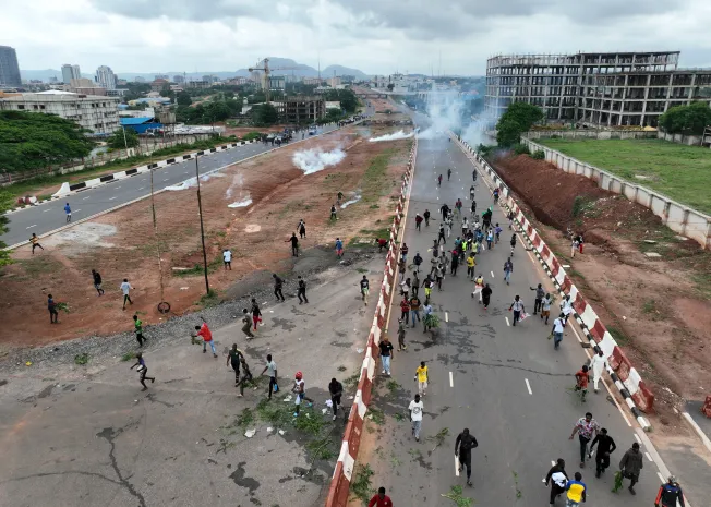 Protestors running from clouds of tear gas fired by Nigerian security forces during the End Bad Governance protests in the capital Abuja on August 2.