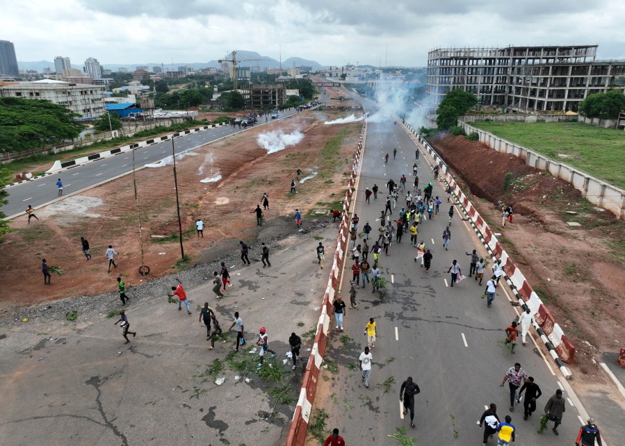 Protestors running from clouds of tear gas fired by Nigerian security forces during the End Bad Governance protests in the capital Abuja on August 2.
