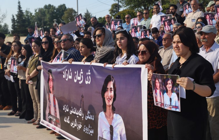 Protesters lift portraits of slain journalists Hero Bahadin (left) and Gulistan Tara in Sulaimaniya, Iraqi Kurdistan, on August 24, 2024.