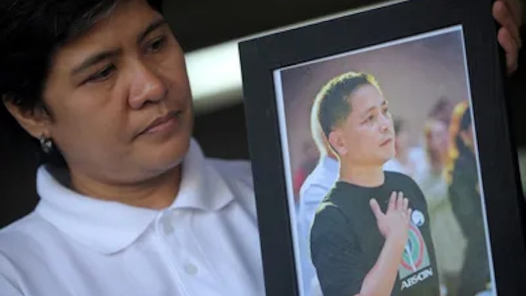 Gerry Ortega’s wife, Patria, holds a photo of the Philippine broadcast journalist, who was murdered in 2011. The alleged mastermind behind his killing, former Palawan governor Joel T. Reyes, has been sentenced to 110 years on graft charges.