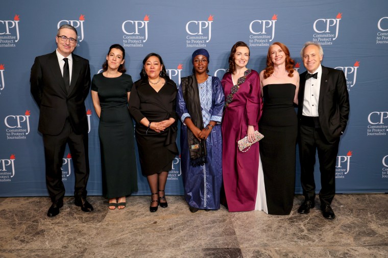 Honorees (beginning third from left) Quimy de Leon, Samira Sabou, and Alsu Kurmasheva, attend CPJ's 2024 International Press Freedom Awards event on November 21 in New York City, along with host John Oliver (left), Perrine Daubas, accepting a posthumous award for her husband, Christophe Deloire, (second from left), CPJ CEO Jodie Ginsberg (second from right), and CPJ Board Chair Jacob Weisberg. Awardee Shrouq Al Aila was not allowed to leave Gaza to attend the event. (Photo: Dia Dipasupil/Getty Images)