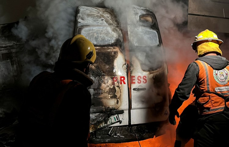 Civil defense members put out a fire in a broadcast van following an Israeli strike on December 26, 2024, that Gaza health authorities say killed five journalists with the Al-Quds Al-Youm television channel. (Photo: Reuters/Khamis Said)