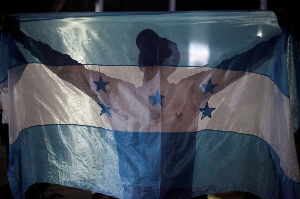 A demonstrator holds a Honduran flag during a protest against Honduras President Xiomara Castro's government and in support of the extradition treaty with the U.S., in Tegucigalpa, Honduras September 6, 2024. REUTERS/Fredy Rodriguez
