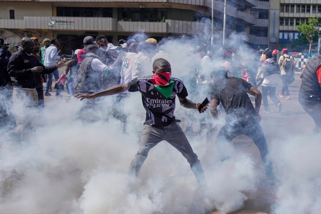 Protesters scatter as police fire teargas at them during a demonstration on the one-year anniversary of deadly anti-tax demonstrations in Nairobi, Kenya, on June 25.