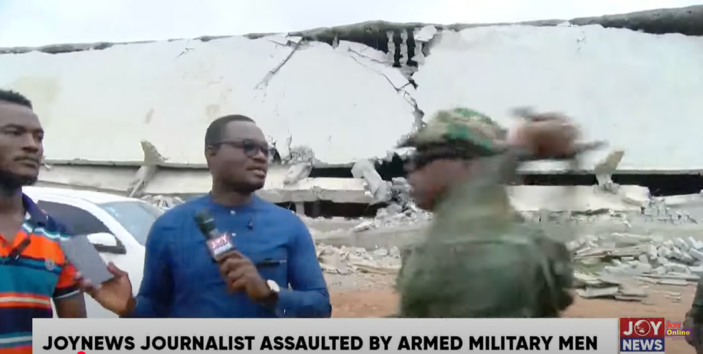 A military officer takes a swing during an interview by a Joy News journalist.