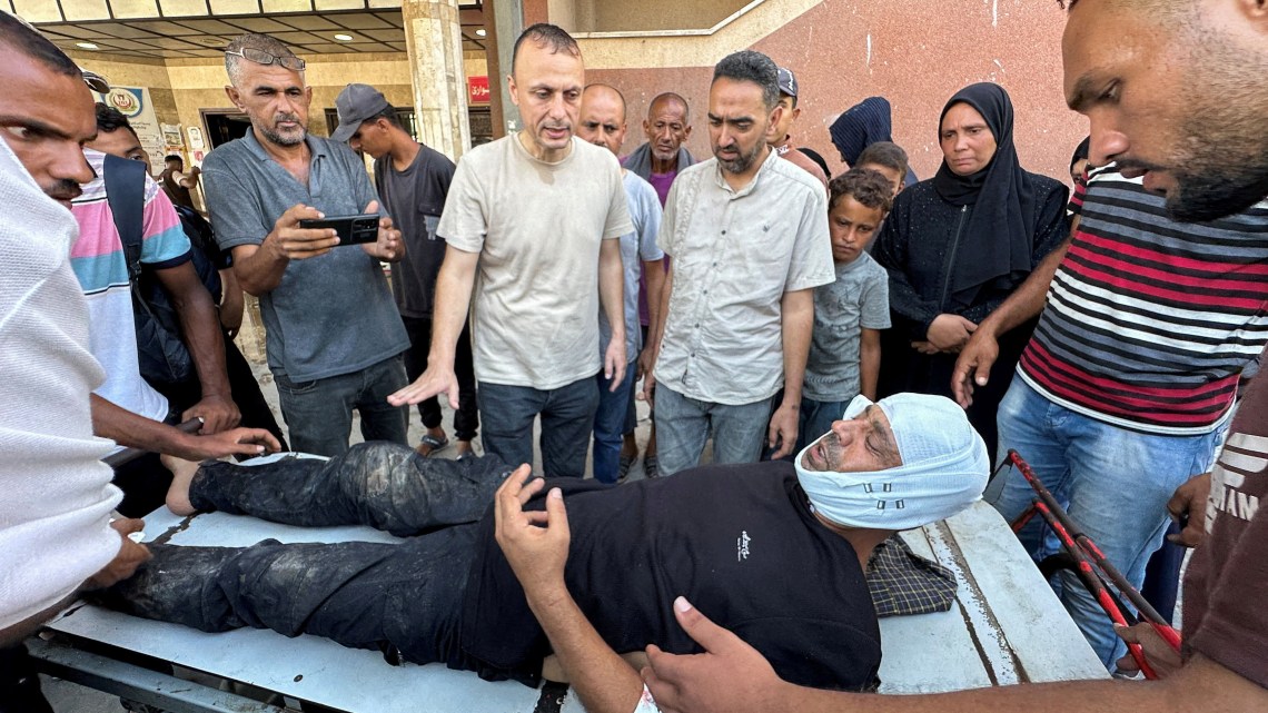 Hatem Khaled, a photographer who contributes to Reuters, is assisted after being wounded in Israeli strikes on Nasser Hospital that killed five journalists on August 25, 2025. (Photo: Reuters/Ramadan Abed)