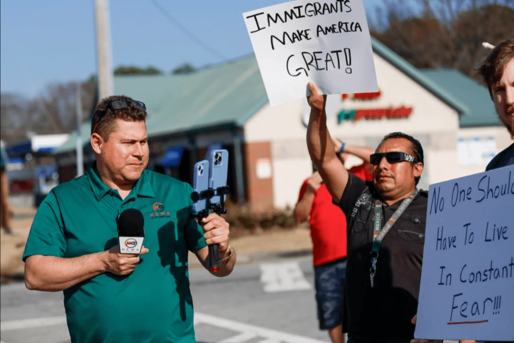 Mario Guevara covers a protest against immigration enforcement on Buford Highway in the Atlanta area on Feb. 1.(Miguel Martinez / Atlanta Journal-Constitution via AP).