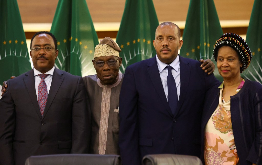 Ethiopian government representative Redwan Hussien, African Union envoy Olesegun Obasanjo, Tigray delegate Getachew Reda and South Africa's former deputy president Phumzile Mlambo-Ngcuka pose after signing the Pretoria Agreement in South Africa on November 2, 2022. 