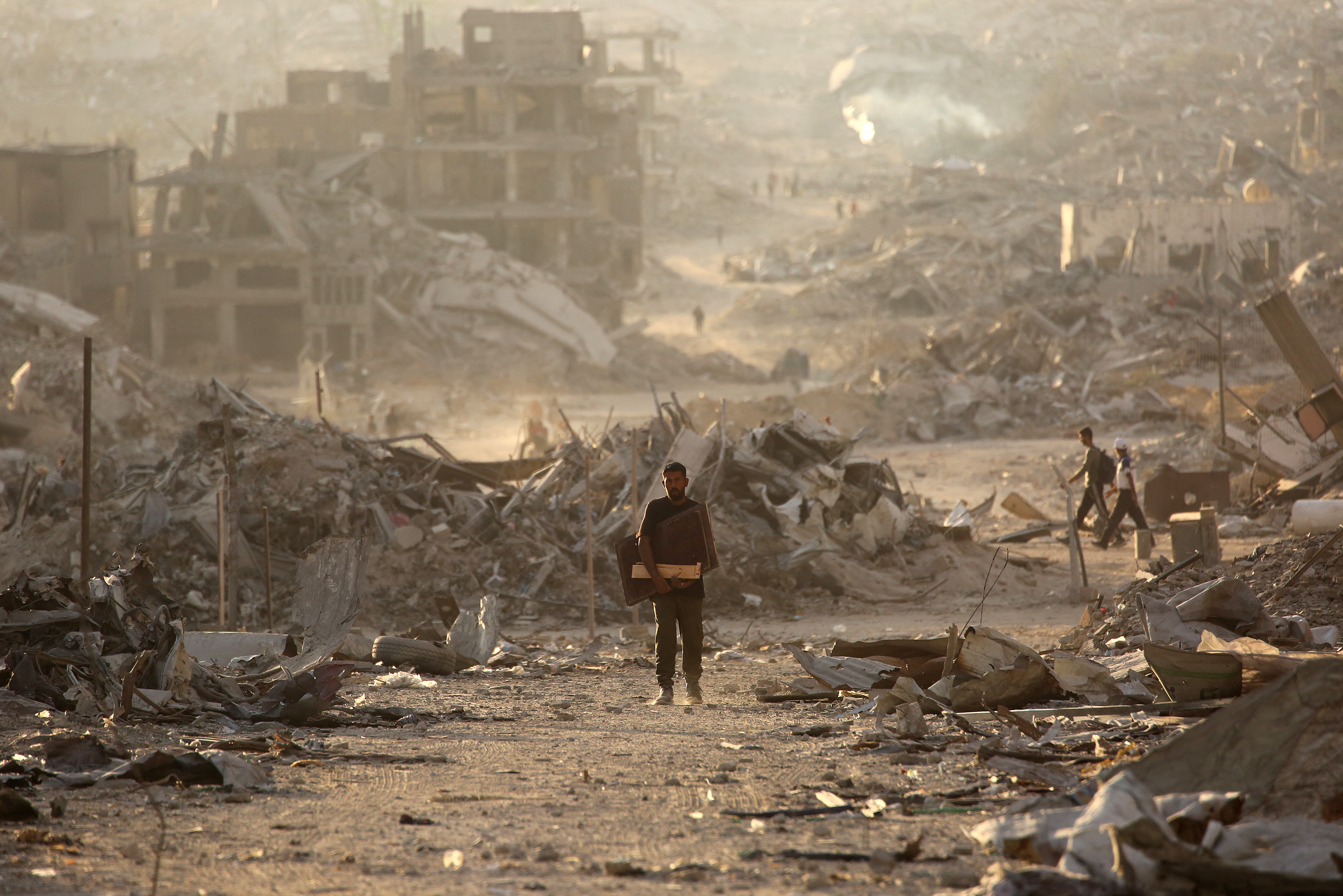 A Palestinian man makes his way past destroyed buildings in Gaza City on October 12, 2025 during a ceasefire.