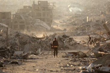 A Palestinian man makes his way past destroyed buildings in Gaza City on October 12, 2025 during a ceasefire.