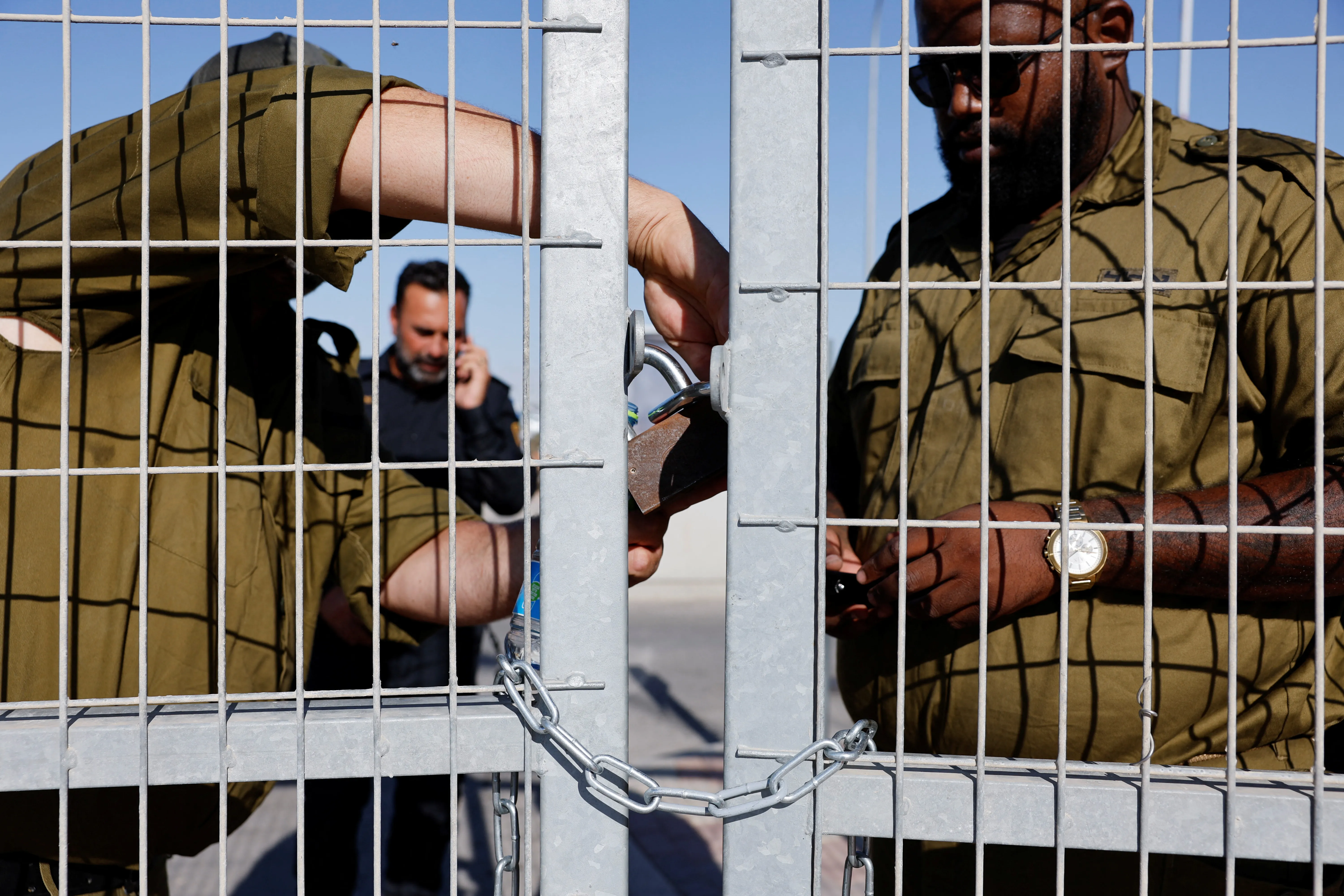 Soldiers lock a gate from the inside at Sde Teiman detention facility, after Israeli military police arrived at the site as part of an investigation into the suspected abuse of a Palestinian detainee.