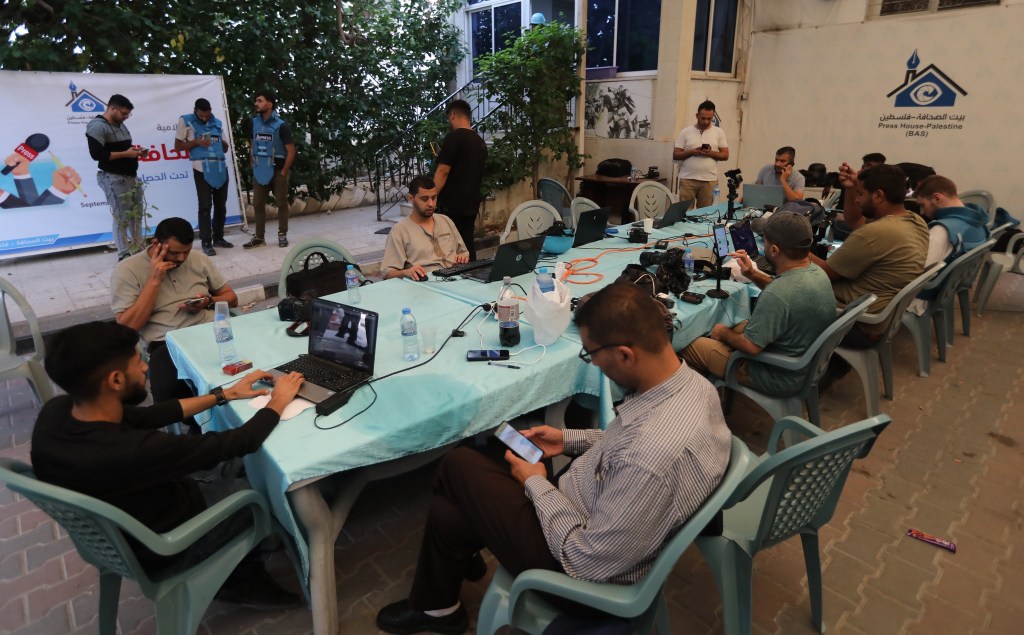 Journalists work in the courtyard outside the Press House headquarters during the last war.