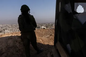 An Israeli soldier is photographed during a military escort looking out from an Israeli military outpost within the borders of the 'yellow line' in the Shujaiya neighborhood in the eastern part of Gaza City in the Gaza Strip, November 5, 2025.