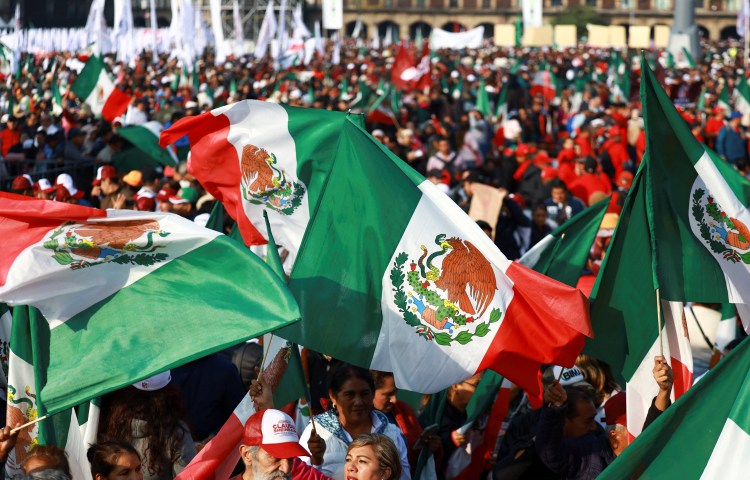 Supporters of Mexico's President Claudia Sheinbaum wave Mexican flags during an event in Zocalo Square to commemorate 7 years since Sheinbaum's party, Morena, came to power, in Mexico City, Mexico, December 6, 2025. REUTERS/Raquel Cunha