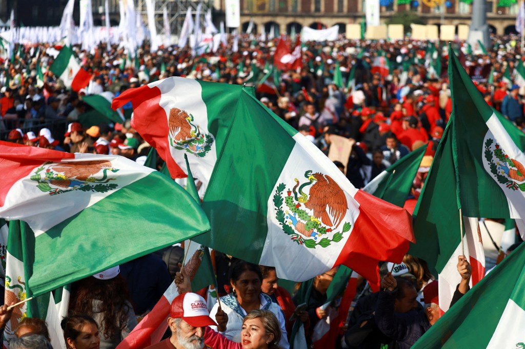 Supporters of Mexico's President Claudia Sheinbaum wave Mexican flags during an event in Zocalo Square to commemorate 7 years since Sheinbaum's party, Morena, came to power, in Mexico City, Mexico, December 6, 2025. REUTERS/Raquel Cunha
