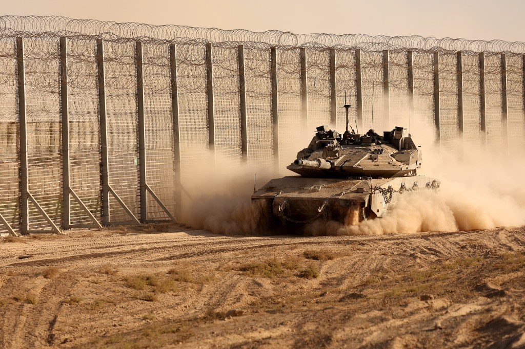 An Israeli army tank moves along the border fence between Israel and the Gaza Strip on October 21, 2025.