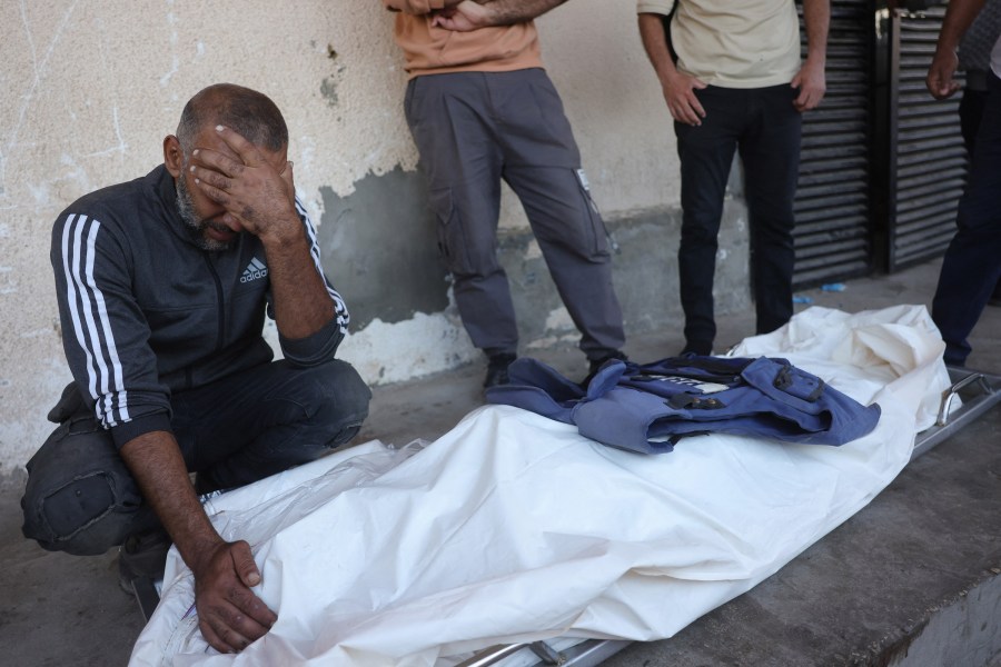 A man mourns over the body of Palestinian media worker Ahmed Abu Mutair, killed in an Israeli strike in the town of Zuwaida in the central Gaza Strip on October 19, 2025., nine days after a ceasefire agreement took effect. (Photo: AFP/Bashar Taleb)
