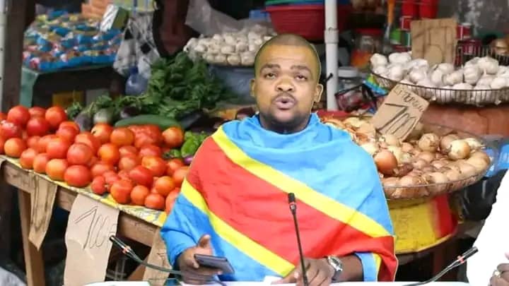 Congolese journalist John Kabamba is seen presenting his show, draped in the national flag.