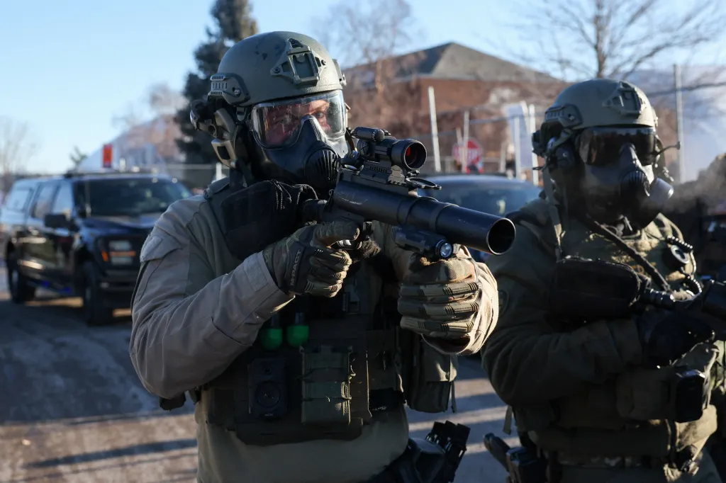 Members of law enforcement hold weapons as they stand guard while people protest outside the Bishop Henry Whipple Federal Building, after the fatal shootings of Renee Nicole Good and Alex Pretti by federal immigration agents, in Minneapolis, Minnesota, U.S., January 30, 2026. REUTERS/Shannon Stapleton