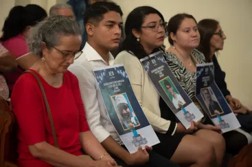Exiled Nicaraguans hold photographs of missing and imprisoned relatives during a Mass in their honor, in San Jose, Costa Rica, Sunday, April 27, 2025. (AP Photo/Jose Diaz)