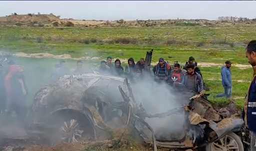 People gather around the aftermath of an Israeli strike on a car that killed three journalists in Gaza on January 21, 2026.