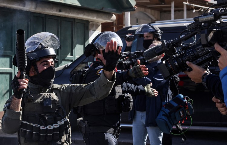 Israeli security forces gesture at journalists amid clashes with Palestinian protesters in Israeli-annexed east Jerusalem on December 22, 2023.