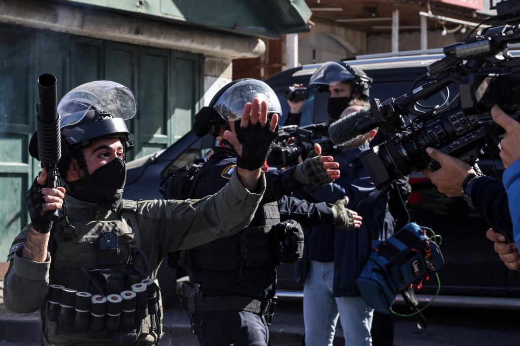 Israeli security forces gesture at journalists amid clashes with Palestinian protesters in Israeli-annexed east Jerusalem on December 22, 2023.