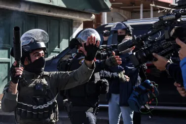 Israeli security forces gesture at journalists amid clashes with Palestinian protesters in Israeli-annexed east Jerusalem on December 22, 2023.