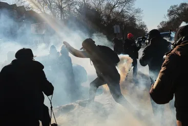 Tear gas covers protesters and photographers in MInneapolis on January 13, 2025, near the scene where Renee Good was fatally shot by an ICE officer a week earlier. (Photo: AP/Adam Gray)