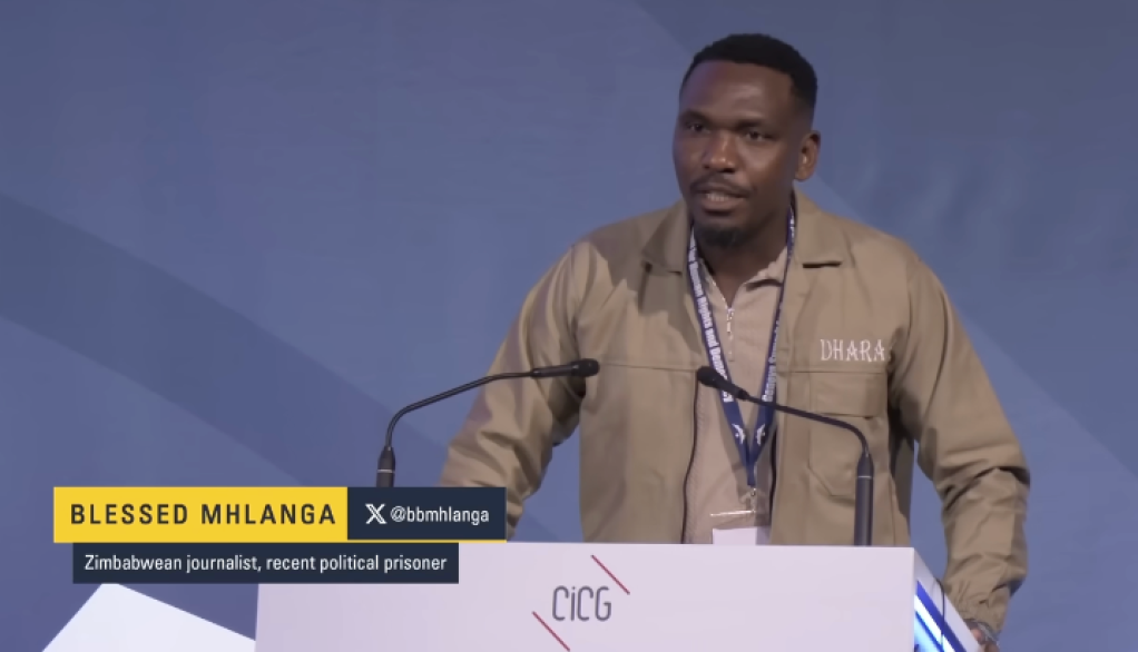 Zimbabwean journalist Blessed Mhlanga speaks at a human rights summit, dressed in his prison uniform, on February 18, 2026.