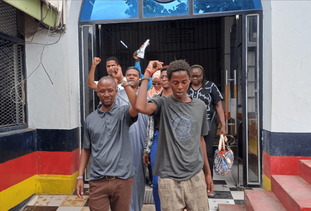 Journalist Peter Maseke Mwita (left) walks out of Central Police Station in Mombasa in handcuffs on January 2, 2026.