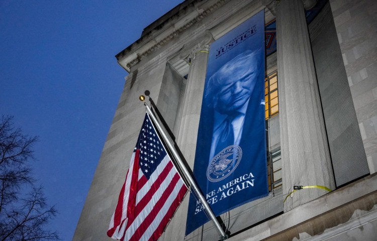 A new banner depicting U.S. President Donald Trump is put up on the Department of Justice building in Washington, D.C., U.S., February 20, 2026. REUTERS/Ken Cedeno