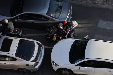 People with children on a scooter weave between cars, as Beirut traffic surges after Israeli army warning prompts residents to evacuate the city's southern suburbs amid the Iran war.