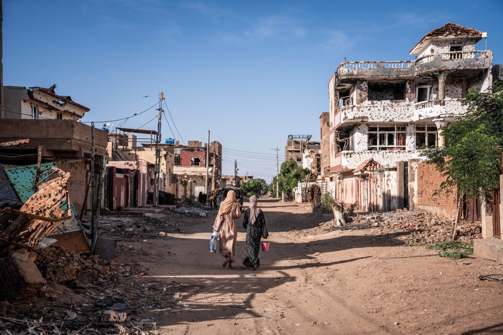 Women walk through a war-torn neighborhood in Sudan's Omdurman on November 2, 2024.