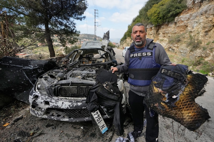 A journalist carries burned safety gear from a car that was hit by an Israeli airstrike, which killed three journalists in south Lebanon on March 28, 2026. (Photo: AP/Mohammed Zaatari)