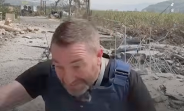 RT correspondent Steve Sweeney ducks to the ground as an Israeli strike hits feet away.