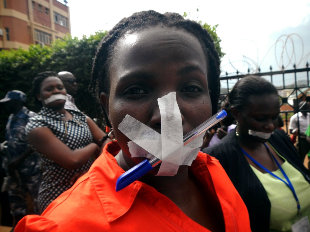 Employees of the Daily Monitor newspaper, with their mouths taped shut, protest the closure of their premises by the government, on May 20, 2013. Police raided Uganda's leading independent newspaper on Monday and disabled its printing press after it published a letter about a purported plot to stifle allegations that Uganda President Yoweri Museveni is grooming his son for power, a senior editor said.
