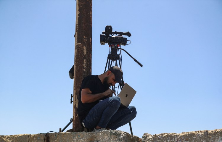 A Palestinian man attempts to access the internet using an eSIM in Gaza City after the internet and fixed-line communications services were cut off amid the Israeli offensive, in June.