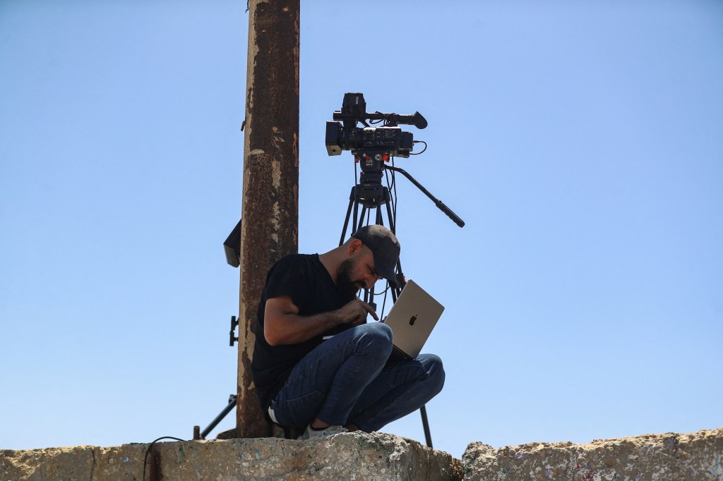 A Palestinian man attempts to access the internet using an eSIM in Gaza City after the internet and fixed-line communications services were cut off amid the Israeli offensive, in June.