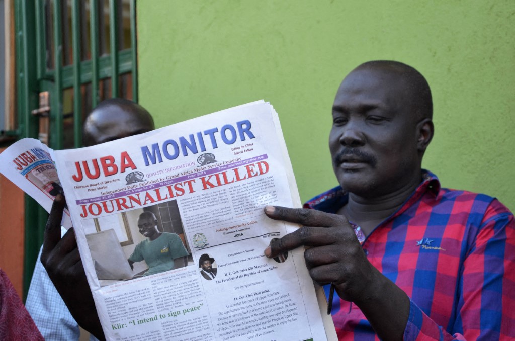 A man reads the Juba Monitor, with a heading referring to the killing of The New Nation's Peter Moi in 2015.