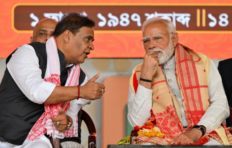 India’s Prime Minister Narendra Modi (R) speaks with Chief Minister of Assam state Himanta Biswa Sarma during a public meeting in Guwahati on February 14, 2026. (Photo: AFP/Biju Boro)