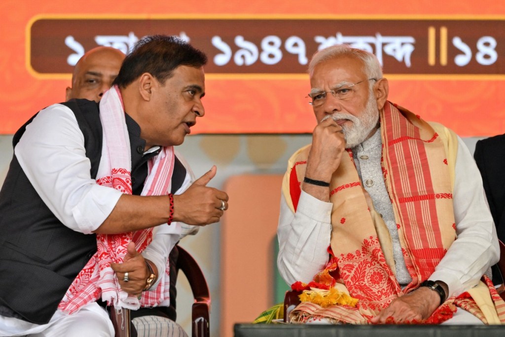 India’s Prime Minister Narendra Modi (R) speaks with Chief Minister of Assam state Himanta Biswa Sarma during a public meeting in Guwahati on February 14, 2026. (Photo: AFP/Biju Boro)
