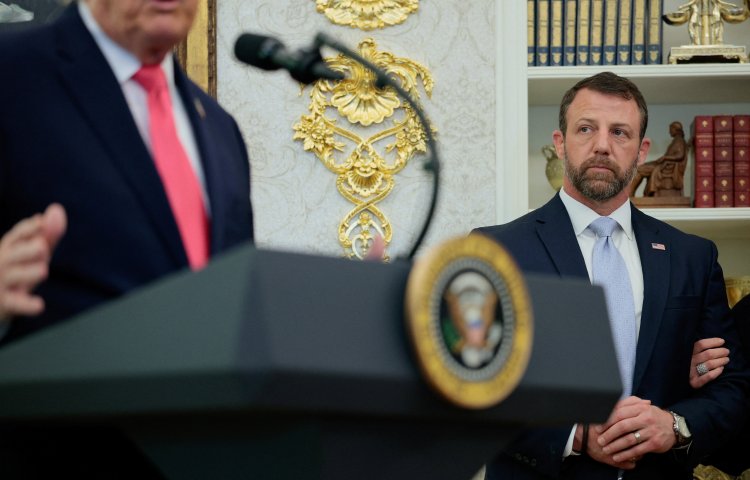 Markwayne Mullin stands listening to U.S. President Donald Trump as he attends his swearing-in as Department of Homeland Security (DHS) Secretary, at the White House in Washington, D.C., U.S., March 24, 2026. REUTERS/Evan Vucci