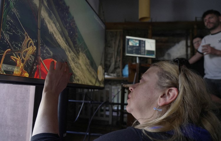 Activists in Athens watch the interception of one of the vessels from the Gaza-bound Global Sumud Flotilla on a video transmission.