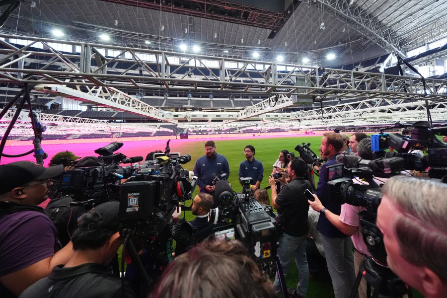 Ewen Hodge, center left, head of pitch infrastructure with FIFA, speaks to reporters during a preview of the grass installed at Dallas Stadium ahead of the 2026 FIFA World Cup, Thursday, May 14, 2026, in Arlington, Texas. (AP Photo/Julio Cortez)