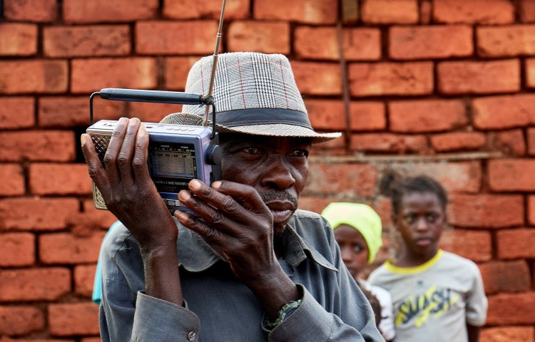 A displaced Congolese man listens to the radio outside his shelter in Fizi territory of South Kivu province in January.