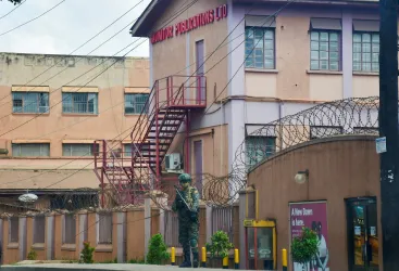A member of Uganda People's Defence Forces stands at the headquarters of Nation Media Group - Uganda, (NMG-U), a building that houses Daily Monitor, KFM and Dembe FM radios, as government closes the media house, in Kampala, Uganda, June 28, 2026.
